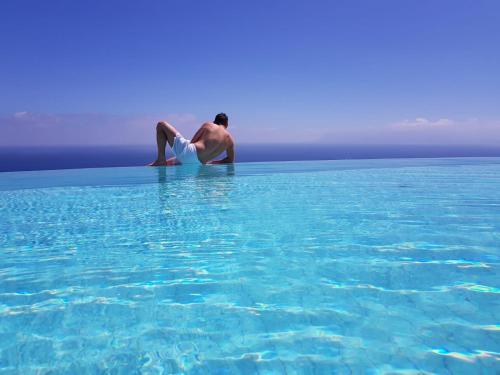 a man sitting in a pool of water at Hotel Antica Cascina Del Golfo in Scopello