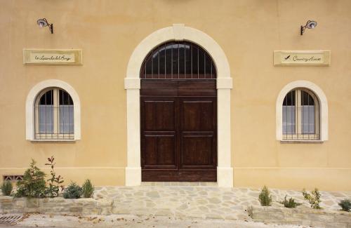 a building with a wooden door and two windows at La Locanda del Borgo in Pietralunga