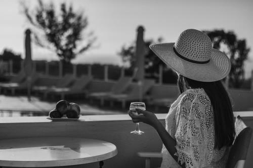 a woman sitting at a table with a glass of wine at Maria's Place - Adults Only in Oia