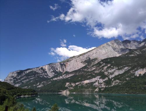 a mountain with a lake in front of it at Hotel Panorama in Molveno