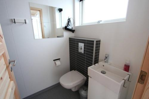 a small bathroom with a toilet and a sink at Blue View Cabin 4B With private hot tub in Reykholt