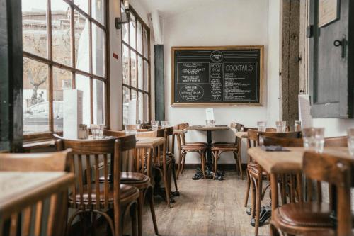 a restaurant with tables and chairs and a chalkboard on the wall at Langley Hotel Gustavia in Chamonix-Mont-Blanc