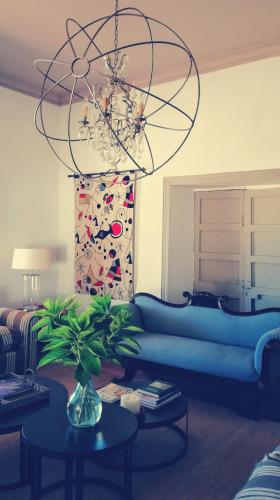 a living room with a blue couch and a chandelier at Casa Bouchon Hotel Boutique in San Javier