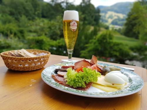 a plate of food and a glass of beer on a table at Hotel Landhaus Sonnenhof in Todtnau