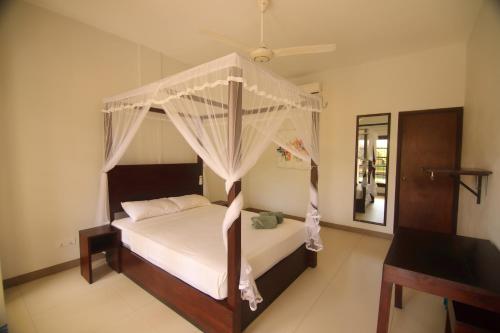 a bedroom with a bed with a canopy at JJ's Hostel Mirissa in Mirissa