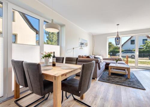 Haus Wellenreiter في بانسين: غرفة معيشة مع طاولة وكراسي خشبية