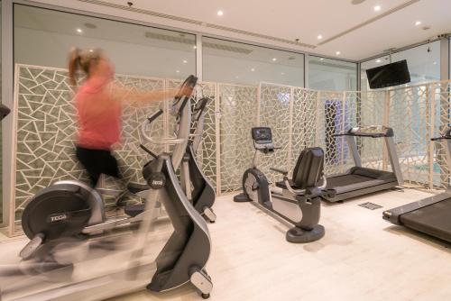 a woman exercising on exercise bikes in a gym at Salvator Villas & Spa Hotel in Parga