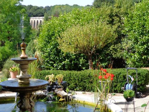 a fountain in the middle of a garden at La Maison Ribotteau in LʼIsle-Jourdain