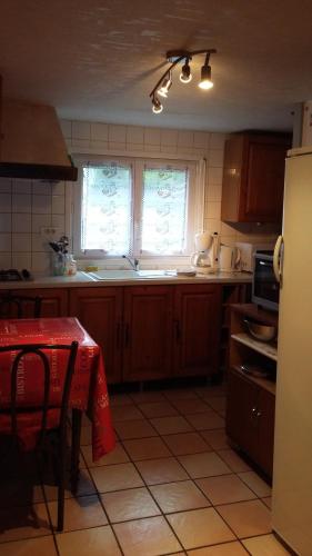 d'une cuisine avec une table et un chiffon rouge. dans l'établissement L'Ecrin de l'Eau Vive, à Xonrupt-Longemer