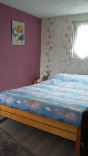 une chambre avec un lit avec une couverture bleue avec des nuages dans l'établissement L'Ecrin de l'Eau Vive, à Xonrupt-Longemer