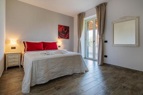 Un dormitorio con una cama con almohadas rojas y una ventana en Lemon Factor Sorrento, en Sorrento