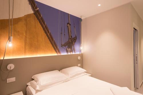 a room with a bed and a painting on the wall at porto canale b & b in Cesenatico