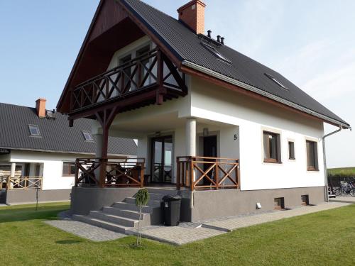 a large white house with a black roof at Sterla - Masuria in Giżycko