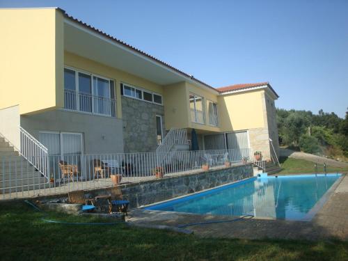 a house with a swimming pool in front of it at Quinta do Toutuço in Arouca