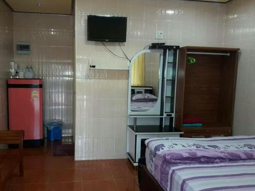 Muean Fhan Resort Aranyaprathet في أرانيابراثيت: غرفة نوم بسرير ومرآة وتلفزيون