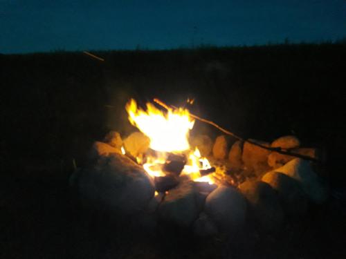 a fire pit with people around it at night at Sterla - Masuria in Giżycko