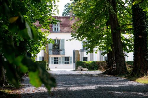 una casa blanca con árboles delante en L' Ecrin des vignes, en Sermiers