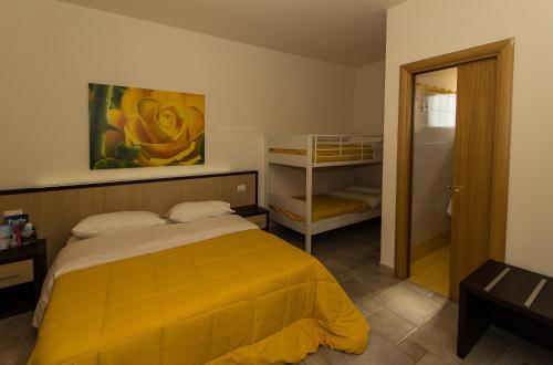 a bedroom with a bed with a yellow blanket at Rifugio Delle Grotte in Castellana Grotte