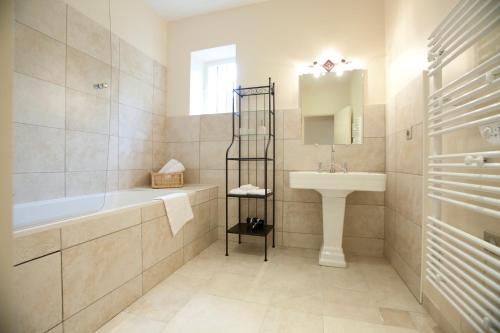 La salle de bains est pourvue d'une baignoire, d'un lavabo et d'un miroir. dans l'établissement Château de Bellevue B&B, à Villié-Morgon