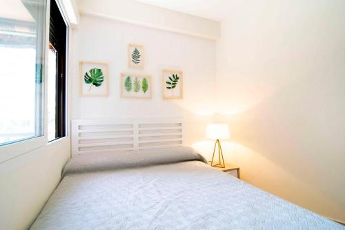 a white bedroom with a bed and a window at Beautiful Apartment next to Santiago Bernabeu by Batuecas in Madrid