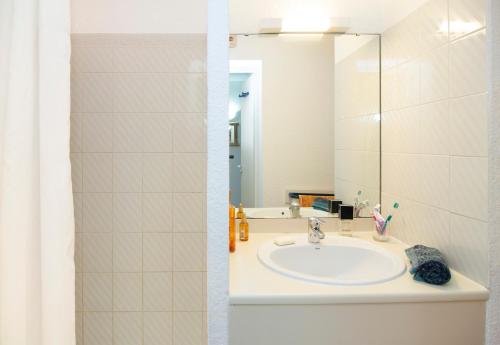 une salle de bain avec un lavabo et un miroir dans l'établissement Vacancéole - La Baie des Anges, au Cap d'Agde