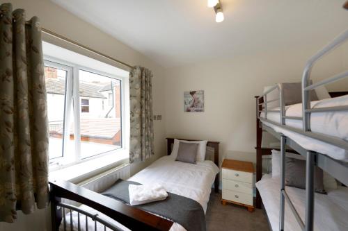 a bedroom with two bunk beds and a window at Southsea Rocks Hotel in Portsmouth