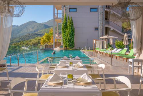 a restaurant with a pool with tables and chairs at Salvator Villas & Spa Hotel in Parga
