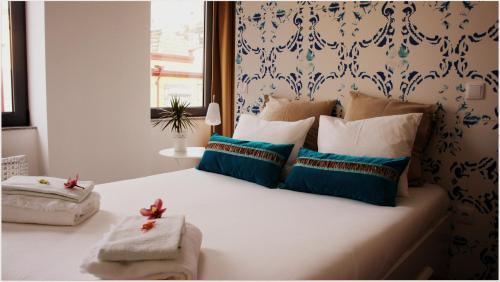 Schlafzimmer mit einem Bett mit blauen und weißen Kissen in der Unterkunft Hostel Gaia Porto in Vila Nova de Gaia