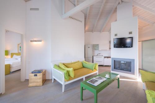 a living room with a couch and a fireplace at Salvator Villas & Spa Hotel in Parga