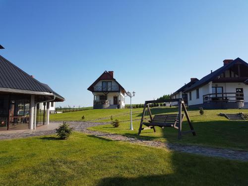 a park with a swing and a house at Sterla - Masuria in Giżycko
