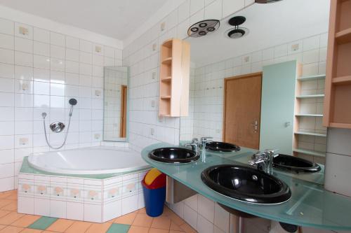 y baño con 2 lavabos y bañera. en Ferienhaus Grohs, en Neumarkt in Steiermark