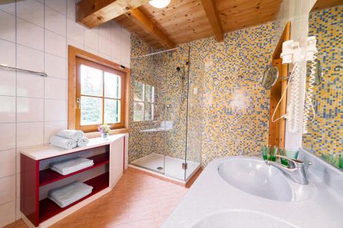 W łazience znajduje się wanna, prysznic i umywalka. w obiekcie Almhütten Moselebauer w mieście Klippitztorl