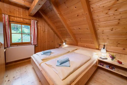 a bedroom in a log cabin with a large bed at Almhütten Moselebauer in Klippitztorl