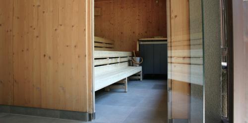 a room with a bench in a room with wooden walls at MONTAFONLodge in Gaschurn