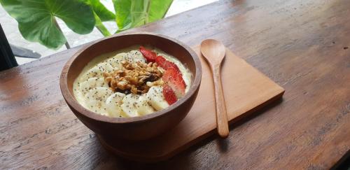 a bowl of food on a wooden table with a spoon at Airlangga Hotel in Yogyakarta