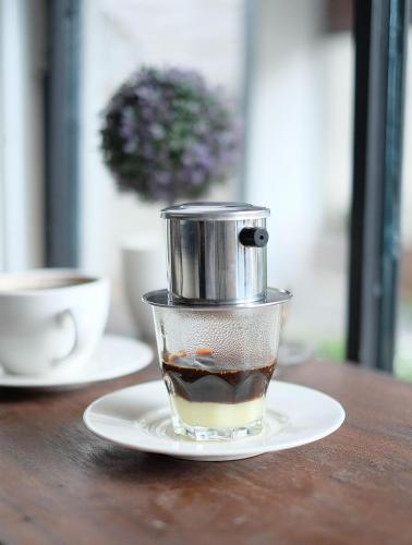 a cup of coffee on a plate on a table at Airlangga Hotel in Yogyakarta