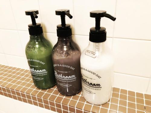 three bottles of detergent on a counter in a bathroom at The Guest House Japan Hakuba in Hakuba