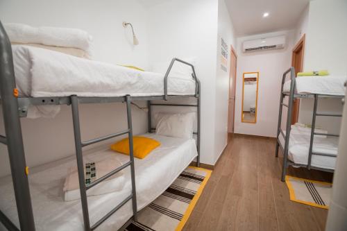 a dorm room with three bunk beds in it at Mocho GuestHouse in São Mamede