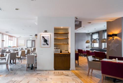 a dining room with tables and chairs and a bar at Hotel Nawigator Szczawnica in Szczawnica