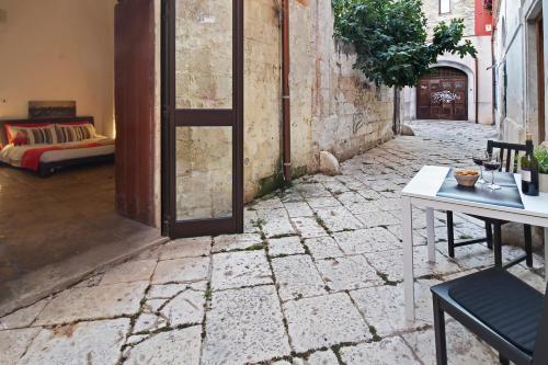 an alley with a door and a table and a couch at B&B Affittacamere Del Teatro in Brindisi