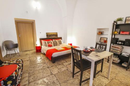 a bedroom with a bed and a table and chairs at B&B Affittacamere Del Teatro in Brindisi