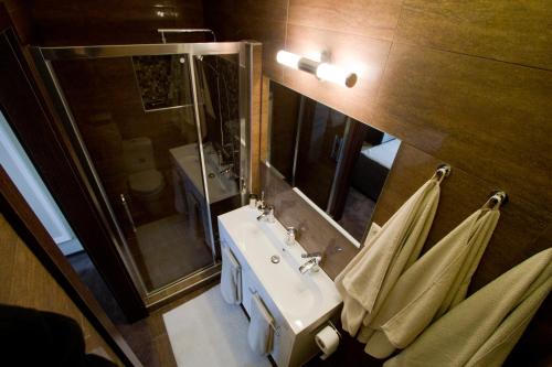 a bathroom with a sink and a mirror and towels at Elisabeth Bridge Apartmans in Budapest