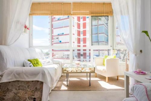 ein Schlafzimmer mit einem Bett und einem großen Fenster in der Unterkunft QBF Quality Beachfront in Torre del Mar