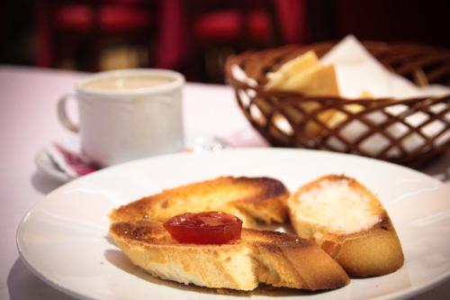 un plato blanco con pan y una taza de café en Hotel Fray Tomás, en Berlanga de Duero