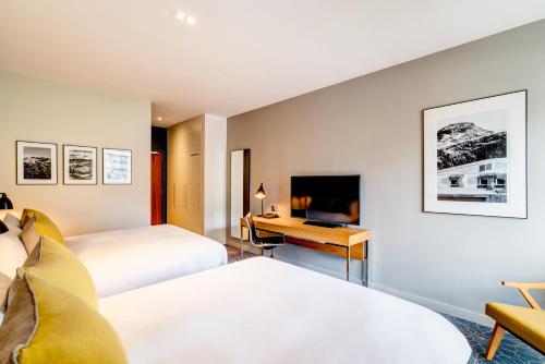 a hotel room with two beds and a desk at Apex Grassmarket Hotel in Edinburgh