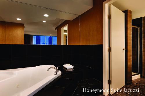 a bathroom with a bath tub and a large mirror at Executive Suites Hotel & Conference Center, Metro Vancouver in Burnaby