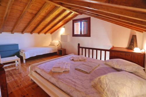 a bedroom with a large bed with two towels on it at Cambos Villa in Skopelos Town