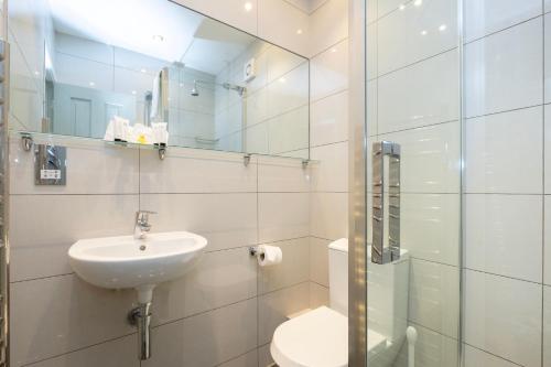 a bathroom with a sink and a toilet and a mirror at Edgar Townhouse in Bath