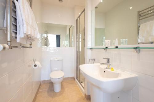 a white bathroom with a toilet and a sink at Edgar Townhouse in Bath
