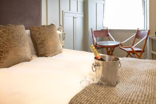 a bed with a bucket on top of it with chairs at Edgar Townhouse in Bath